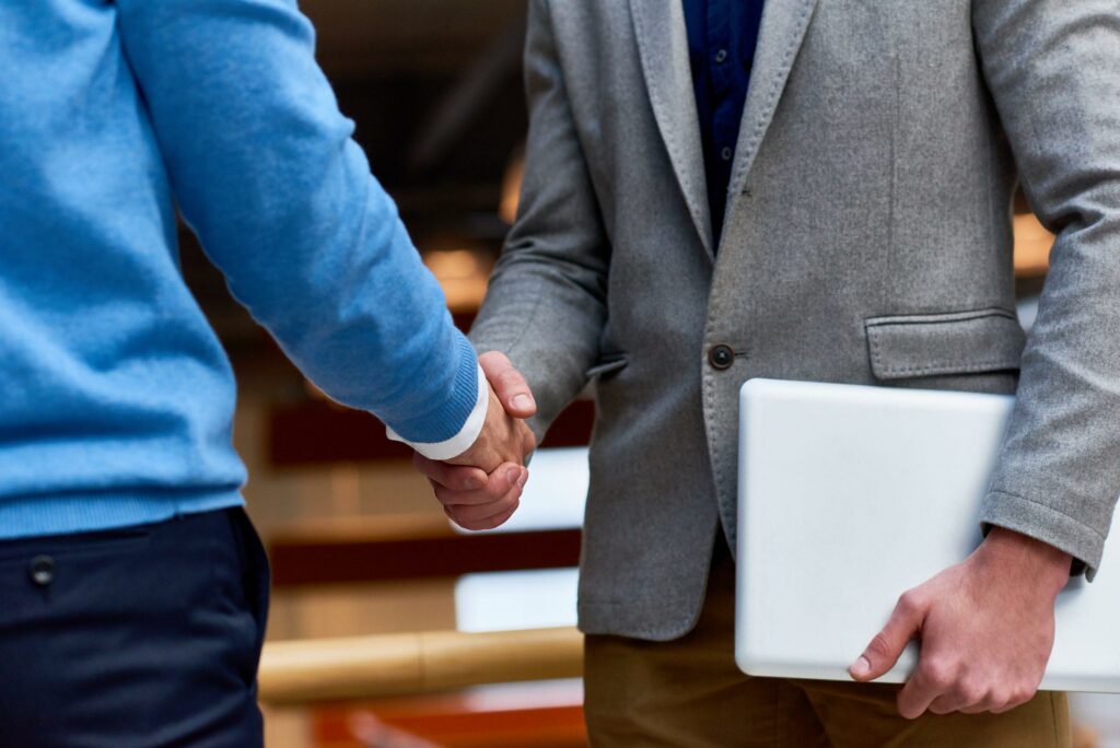 Apretón de manos entre profesionales, símbolo de confianza y acuerdos respaldados por los seguros de caución de Sammy Free para empresas y proyectos.